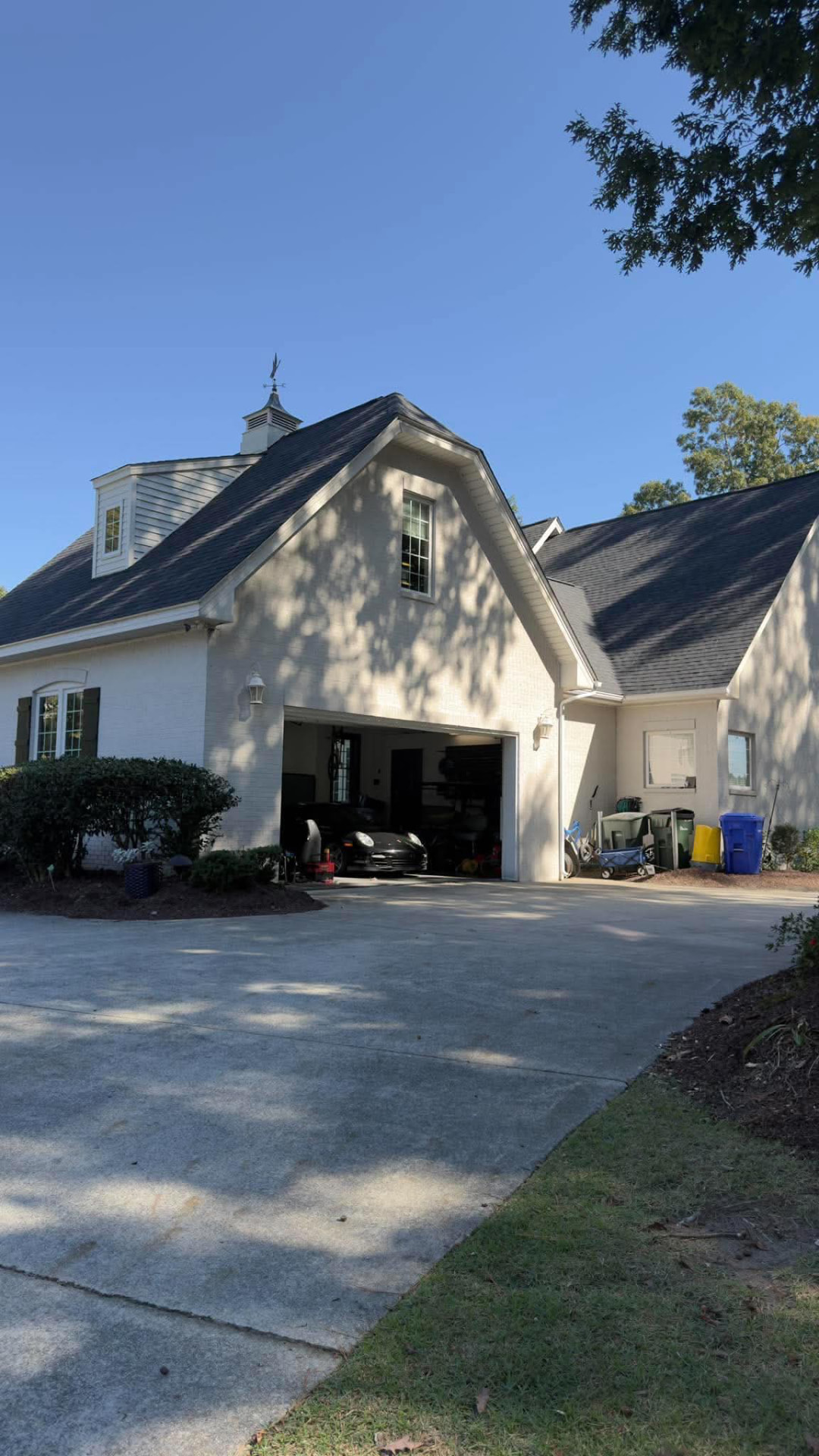 White brick home with a newly installed dark architectural shingle roof