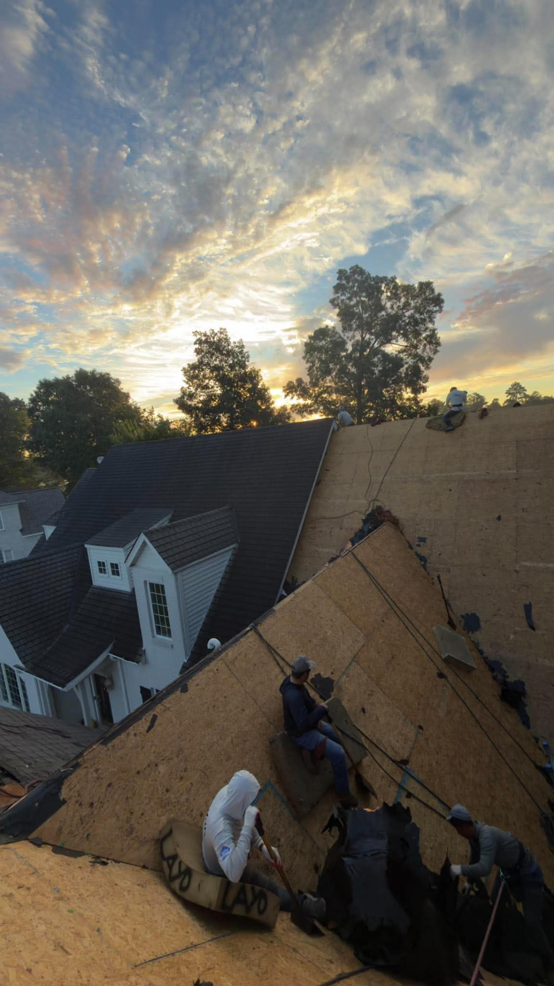 DAWC crew tearing off old shingles down to the roof deck during a residential roof replacement