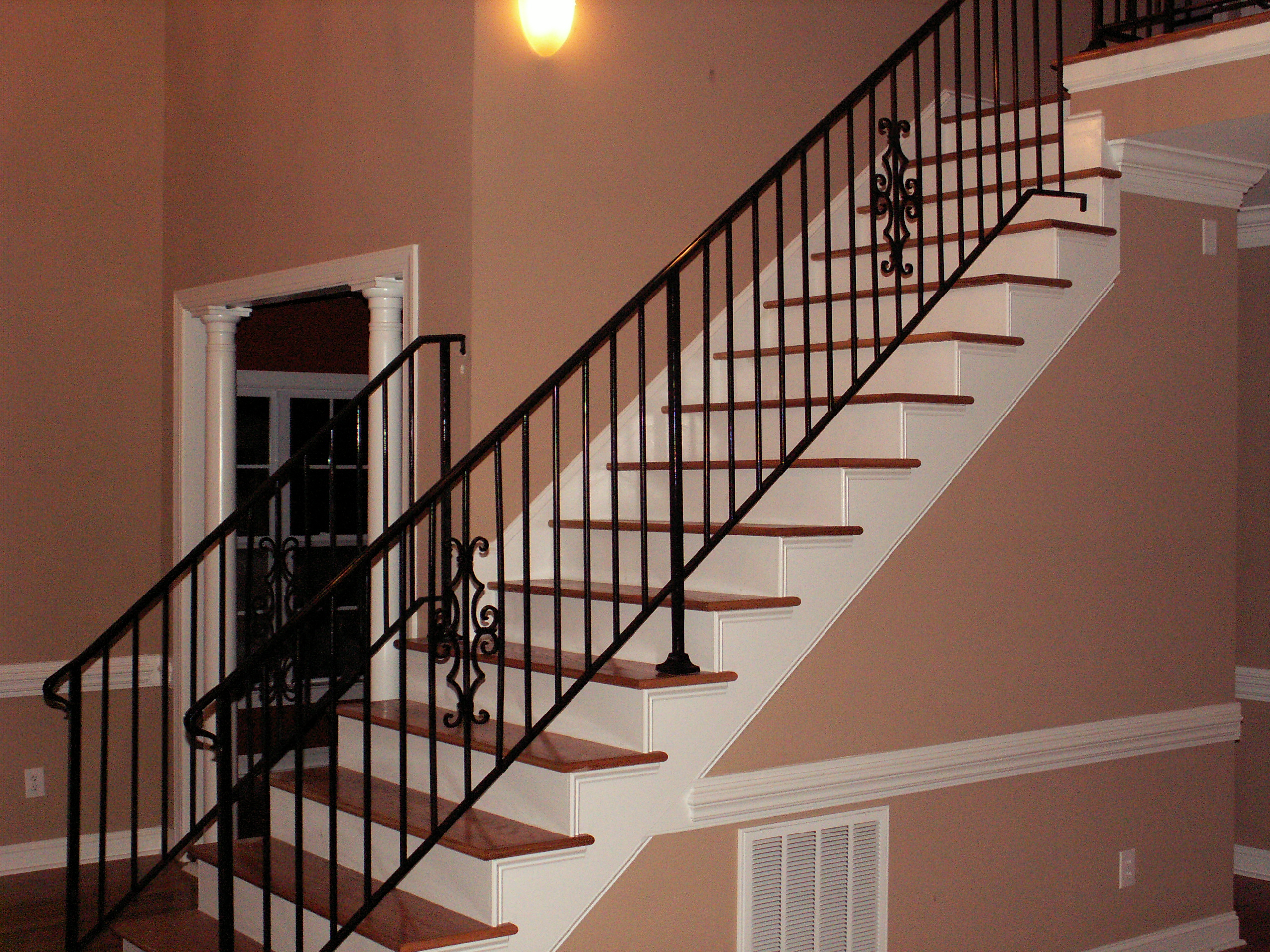 Black metal interior stair railing beside white stair treads