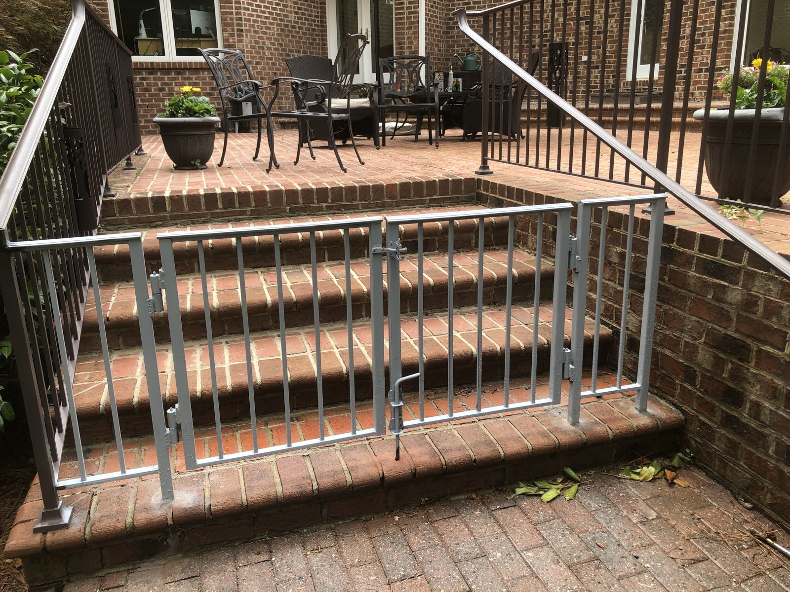 Metal railings around wood deck steps and an outdoor landing