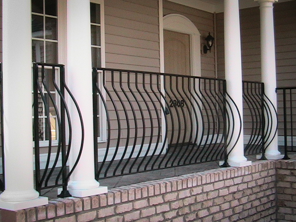 Curved black iron belly rail along a front porch